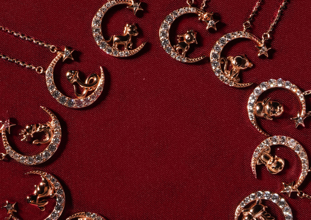 Deretan koleksi Chinese Zodiac perak S925 warna rosegold di atas kain merah.