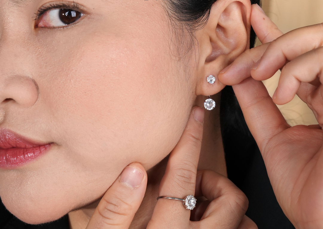 Close up model mengenakan anting silver 925 DAVINA warna silver dengan batu bulat bening serta cincin berkilau.