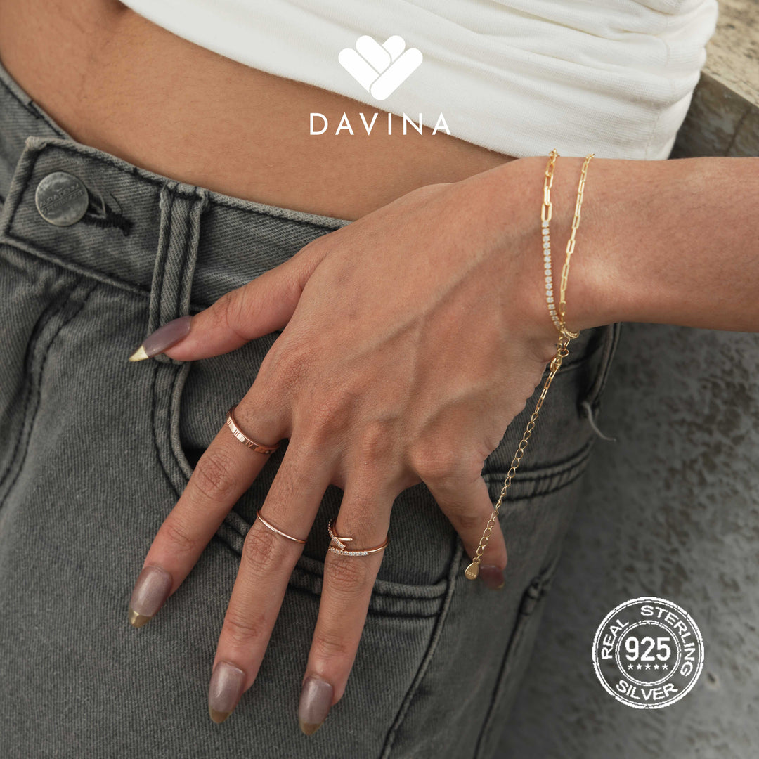 Tampilan close-up tangan dengan set cincin rose gold dari DAVINA—Gilena Ring, Adele Ring, dan Ziva Ring—dipadukan dengan gelang gold edgy Leonax Bracelet. Gaya edgy feminin yang bold namun tetap elegan.