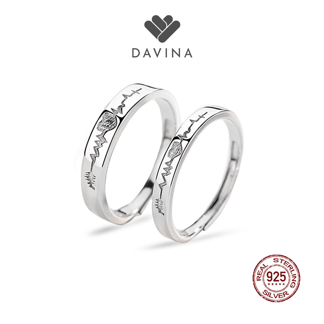 A pair of sterling silver rings with an engraved heart beat design.
